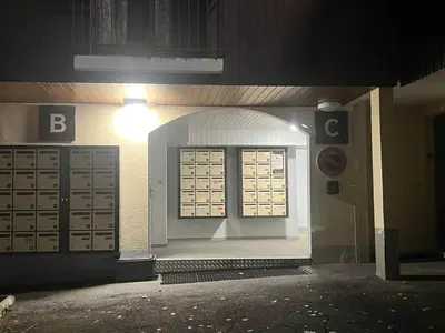 an entrance to a building with a door and a light at Escapade aux Carroz in Arâches-la-Frasse