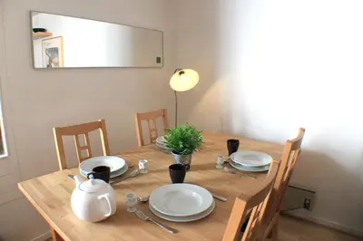 a wooden table with plates and utensils on it at Apartment with terrace Gentianes 1 Centre Chamonix by Aiguille du Midi in Chamonix-Mont-Blanc