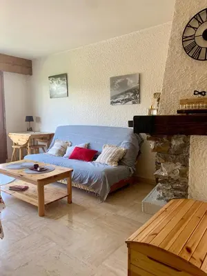 a living room with a blue couch and a table at Apartment near the slopes in Combloux in Combloux