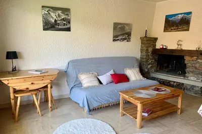 a living room with a blue couch and a fireplace at Apartment near the slopes in Combloux in Combloux