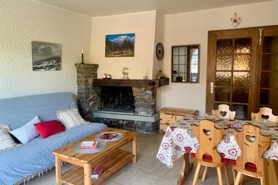 a living room with a blue couch and a fireplace at Apartment near the slopes in Combloux in Combloux