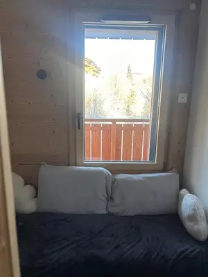a bed in a room with a large window at Appartement standing 3 chambres, Luxury 3-bedroom apartment 75m2 in Arâches-la-Frasse