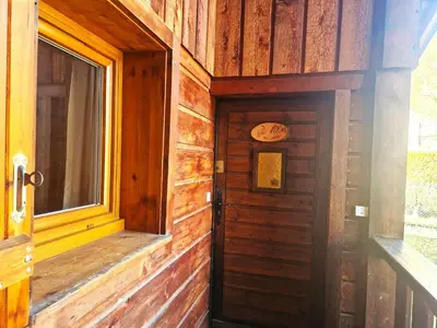 a wooden door in a room with a window at Bel-Achat Vue MontBlanc in Chamonix-Mont-Blanc
