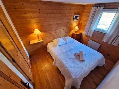 a bedroom with a bed with a white blanket at Bel-Achat Vue MontBlanc in Chamonix-Mont-Blanc