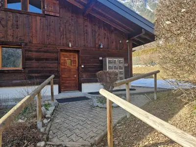 a wooden cabin with a door and a porch at Bel-Achat Vue MontBlanc in Chamonix-Mont-Blanc