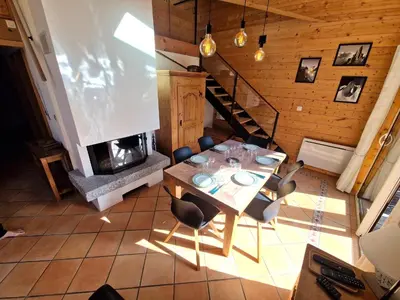 a dining room with a table and a fireplace at Bel-Achat Vue MontBlanc in Chamonix-Mont-Blanc