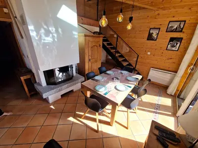 a dining room with a table and a fireplace at Bel-Achat Vue MontBlanc in Chamonix-Mont-Blanc