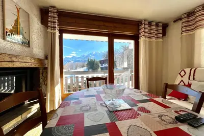a dining room with a table and a large window at Mont Blanc view and hiking trails in Combloux in Combloux
