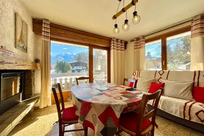 a dining room with a table and a couch at Mont Blanc view and hiking trails in Combloux in Combloux