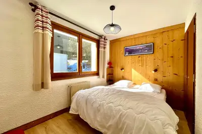 a bedroom with a bed and a window at Mont Blanc view and hiking trails in Combloux in Combloux