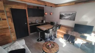 a living room with a couch and a table at Beau studio dans un chalet in Les Houches