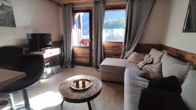 a log cabin with snow covered mountains in the background at Beau studio dans un chalet in Les Houches