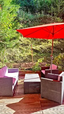 a red umbrella sitting on a deck with chairs at Cozy Bellevue - outdoor, skiing in Les Houches in Les Houches