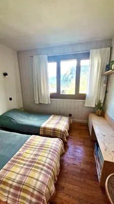 two beds in a room with two windows at Cozy Bellevue - outdoor, skiing in Les Houches in Les Houches