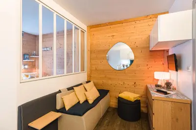 a living room with a couch and a mirror at Vue montagne parking privé balcon in Chamonix-Mont-Blanc