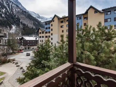 a balcony with a view of a street and mountains at Vue montagne parking privé balcon in Chamonix-Mont-Blanc