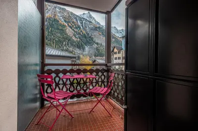 a balcony with a table and a view of a mountain at Vue montagne parking privé balcon in Chamonix-Mont-Blanc