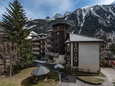 an apartment building with a gazebo in front of a mountain at Vue montagne parking privé balcon in Chamonix-Mont-Blanc