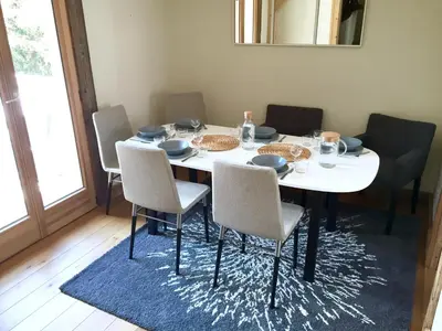 a dining room table with chairs and a white table with food on it at Chamonix Apartment in Chamonix-Mont-Blanc