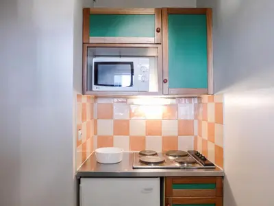 a small kitchen with a stove and a microwave at Apartment Le Chamois Blanc-8 by Interhome in Chamonix-Mont-Blanc