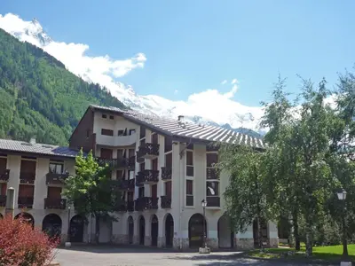 a large building with a mountain in the background at Studio Le Triolet-6 by Interhome in Chamonix-Mont-Blanc