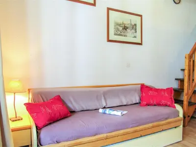 a purple couch with red pillows in a room at Studio Le Triolet-6 by Interhome in Chamonix-Mont-Blanc
