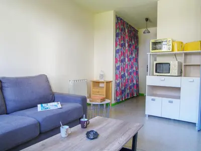 a living room with a blue couch and a table at Studio Gentiane-5 by Interhome in Chamonix-Mont-Blanc