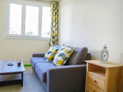 a living room with a blue couch and a window at Studio Gentiane-5 by Interhome in Chamonix-Mont-Blanc