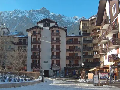 a large apartment building with snowy mountains in the background at Studio La Forclaz-6 by Interhome in Chamonix-Mont-Blanc