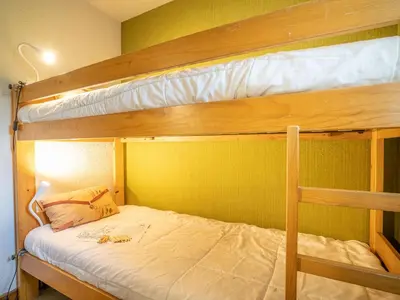 a bedroom with two bunk beds with white sheets at Apartment Clos des Outannes-1 by Interhome in Chamonix-Mont-Blanc