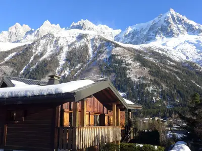 a parking lot with cars parked in front of a mountain at Apartment Clos des Outannes-1 by Interhome in Chamonix-Mont-Blanc