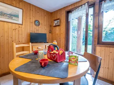 a kitchen with a table with a tv and a tableablish at Apartment Clos des Outannes-1 by Interhome in Chamonix-Mont-Blanc