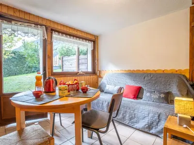 a room with a table and a bed and a table and chairs at Apartment Clos des Outannes-1 by Interhome in Chamonix-Mont-Blanc