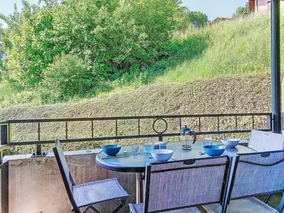 a table with bowls and glasses on top of a balcony at Apartment Clos de la fontaine 2 by Interhome in Saint-Gervais-les-Bains