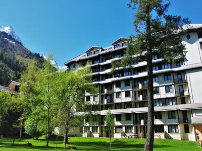 a large building with trees in front of it at Apartment Le Chamois Blanc-10 by Interhome in Chamonix-Mont-Blanc