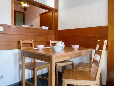 a wooden table and chairs with bowls on it at Apartment Le Chamois Blanc-10 by Interhome in Chamonix-Mont-Blanc