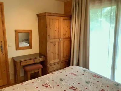 a bedroom with a bed and a dresser and a mirror at Residence Le Pas Au Loup in Samoëns