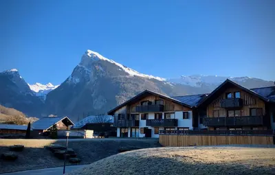 a building with a mountain in the background at Residence Le Pas Au Loup in Samoëns