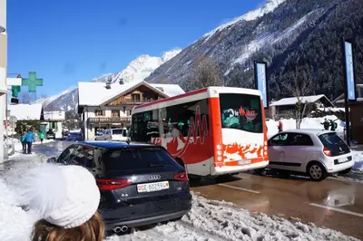 a bus is parked in a parking lot with cars at Aiguille du Midi - Le Chamo'nid in Chamonix-Mont-Blanc