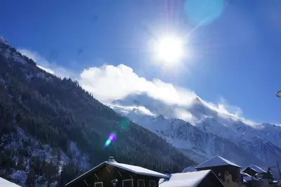 a snow covered mountain with the sun in the sky at Aiguille du Midi - Le Chamo'nid in Chamonix-Mont-Blanc