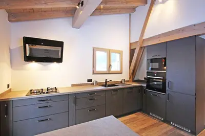 a large kitchen with gray cabinets and a microwave at Chalet De L'ours - Chamonix All Year in Chamonix-Mont-Blanc
