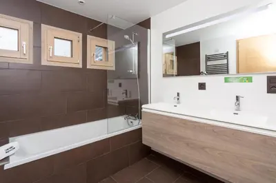 a bathroom with two sinks and a tub and a mirror at Chalet De L'ours - Chamonix All Year in Chamonix-Mont-Blanc