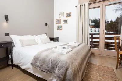 a bedroom with a bed and a desk and a window at Chalet De L'ours - Chamonix All Year in Chamonix-Mont-Blanc
