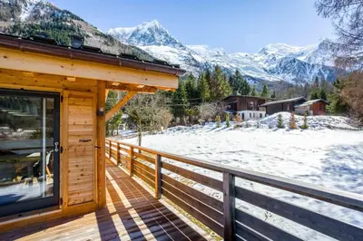 a wooden deck with a view of a snow covered mountain at Chalet De L'ours - Chamonix All Year in Chamonix-Mont-Blanc
