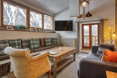 a living room with a couch and a table at Loft Apartment High Rimaye - Mont Blanc Views, Close to Brevent in Chamonix-Mont-Blanc