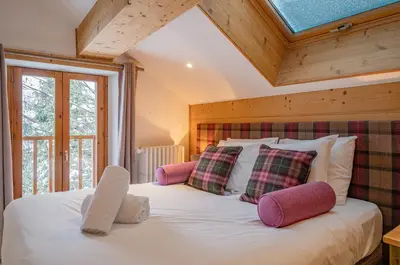 a bedroom with a bed with pillows and a window at Loft Apartment High Rimaye - Mont Blanc Views, Close to Brevent in Chamonix-Mont-Blanc