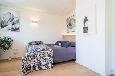 a bedroom with a bed and a chair at Chalet à Megève-Vauvray - Grands Appartements , vue Mont Blanc in Demi-Quartier