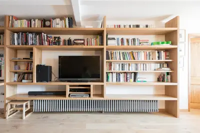 a book shelf with a television in a living room at Chalet à Megève-Vauvray - Grands Appartements , vue Mont Blanc in Demi-Quartier
