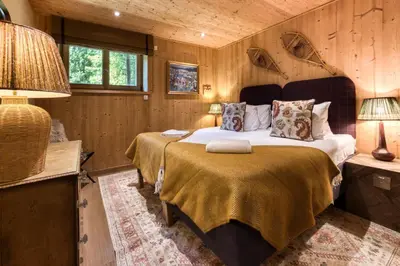 a bedroom with two beds in a room with wooden walls at Apartment Au Bon Coin - Luxury Chamonix Hidden Haven, Mont Blanc view, Hot Tub and Garden in Chamonix-Mont-Blanc