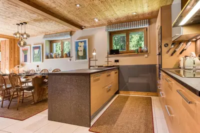 a kitchen with a large island and a dining room at Apartment Au Bon Coin - Luxury Chamonix Hidden Haven, Mont Blanc view, Hot Tub and Garden in Chamonix-Mont-Blanc